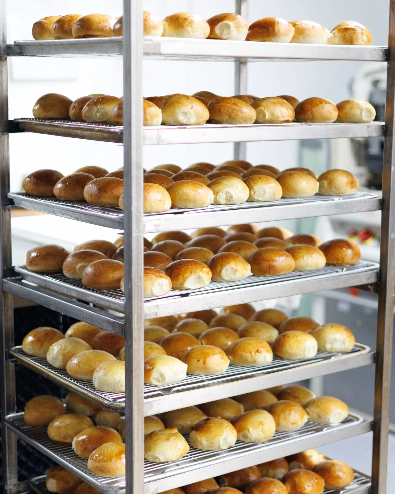 Trays of golden-brown buns cooling on racks at Michaels Bakery in Orrville Ohio