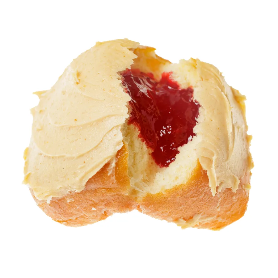 A peanut butter and jelly donut split open to show the strawberry jelly filling under peanut butter icing, from Michaels Bakery in Orrville, Ohio